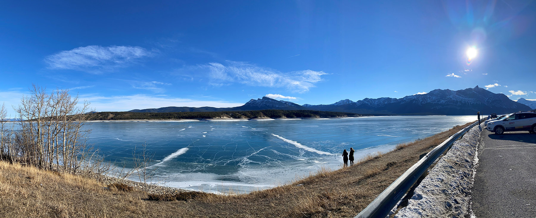 Frozen blue glacier lake with the mountains in the back ground and a vibrant blue sky