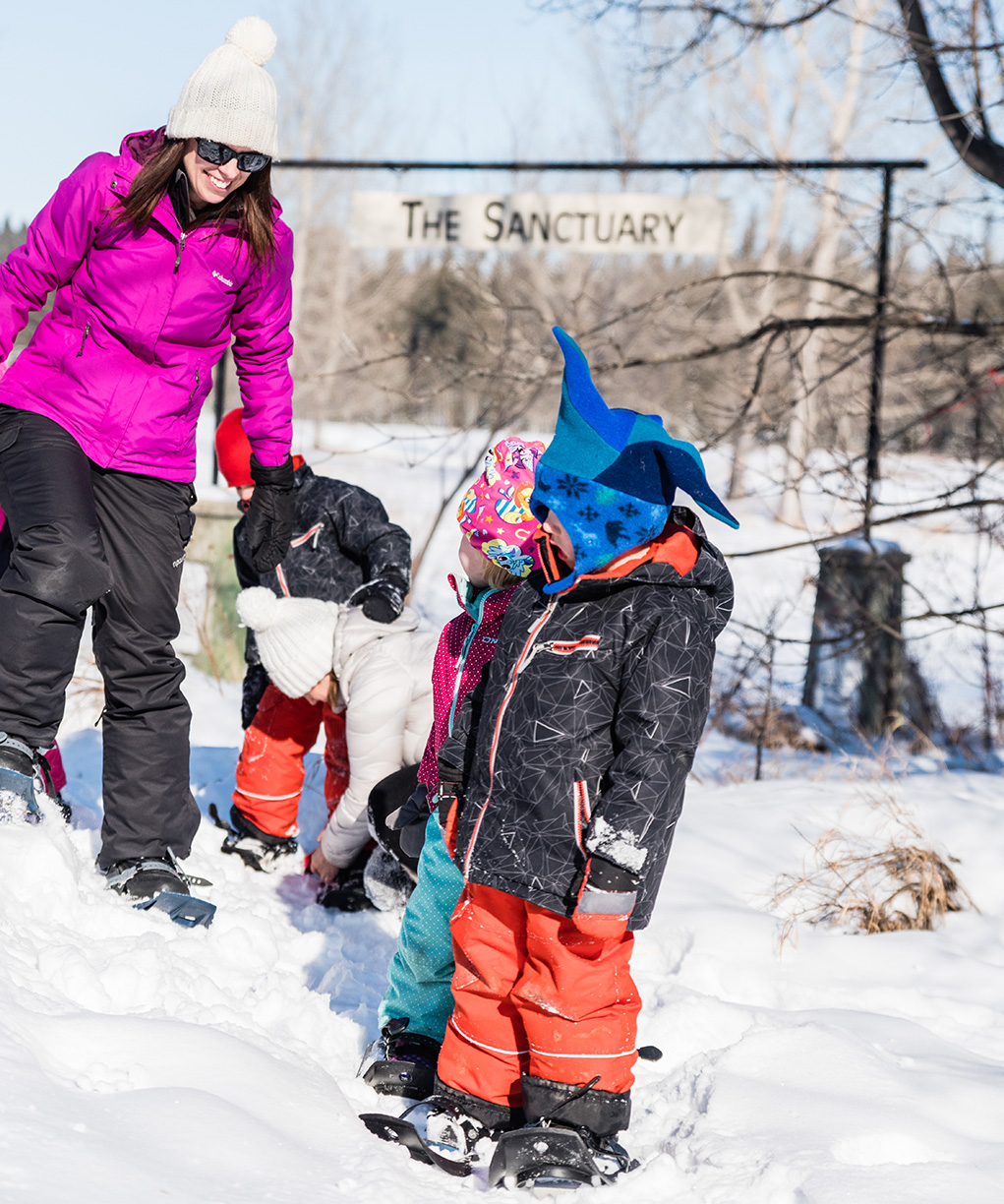 A teacher helps some children put on their snow shoes ready for a trek in Kerry Wood Nature Centre