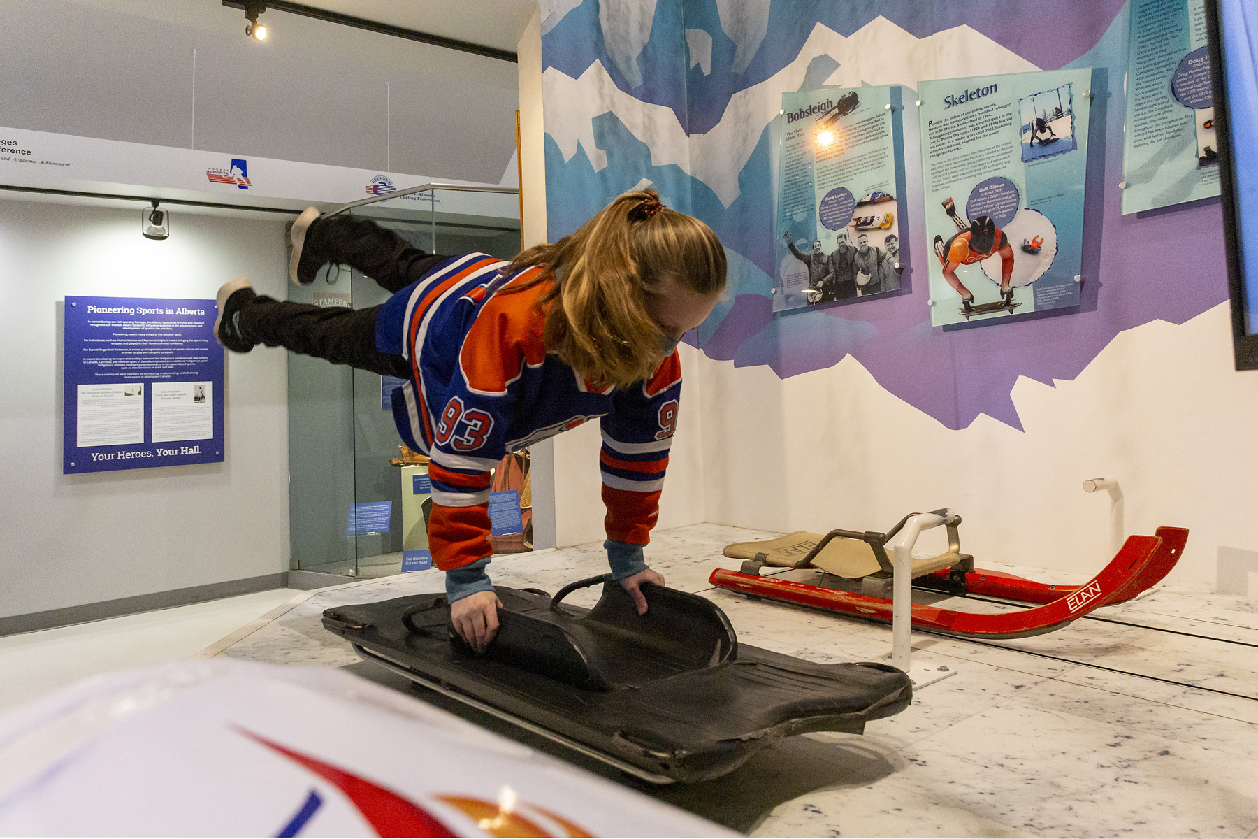 Two girl curing in the Alberta Sports Hall of Fame. 