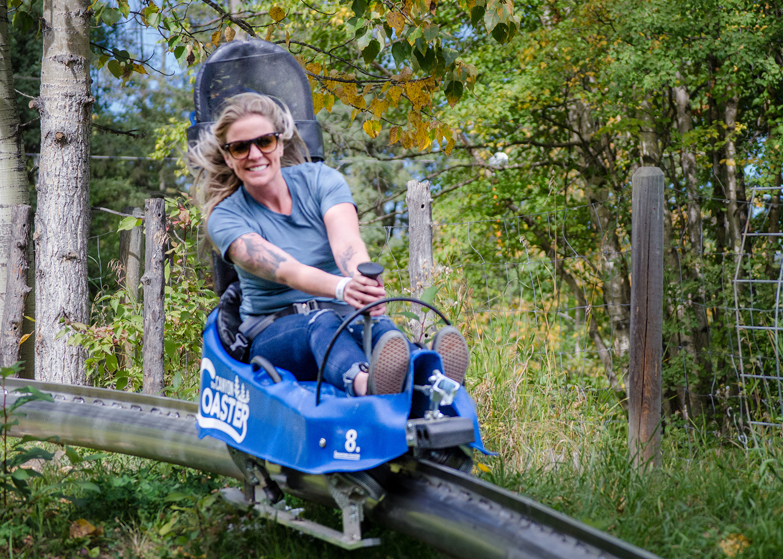 Woman roaring down Canyon Alpine Coaster at Canyon Ski Hill in Red Deer, Alberta