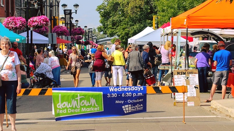 A crowd of people enjoying the downtown farmers market. 